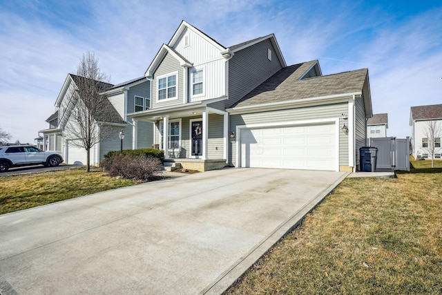 view of front of home featuring covered porch, a garage, and a front lawn