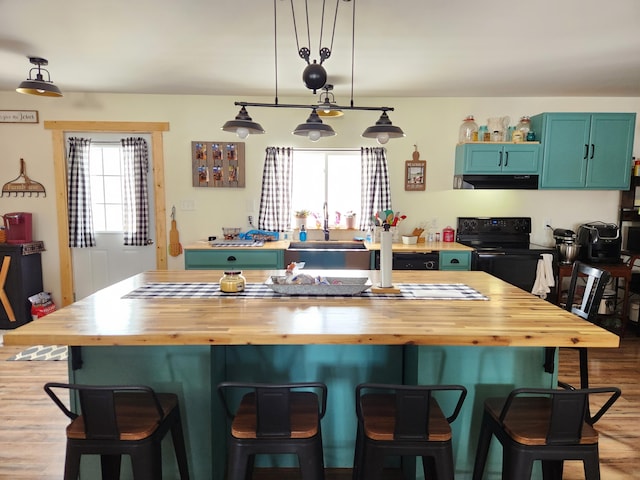 kitchen with pendant lighting, butcher block countertops, and a breakfast bar area