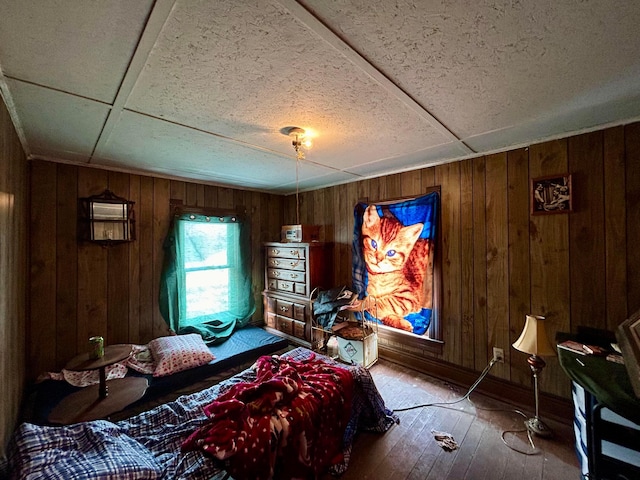 bedroom featuring wood walls and wood finished floors