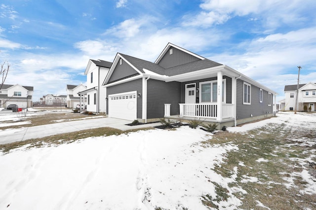 view of front of home featuring driveway, a porch, an attached garage, and a residential view