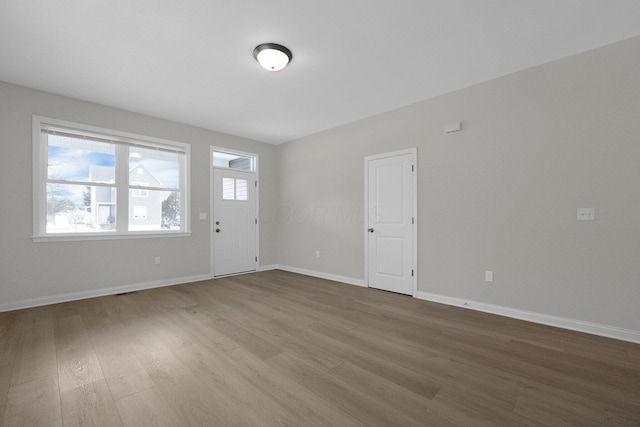 unfurnished room featuring baseboards and wood finished floors