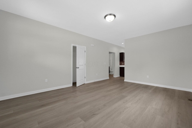 empty room with baseboards and wood finished floors