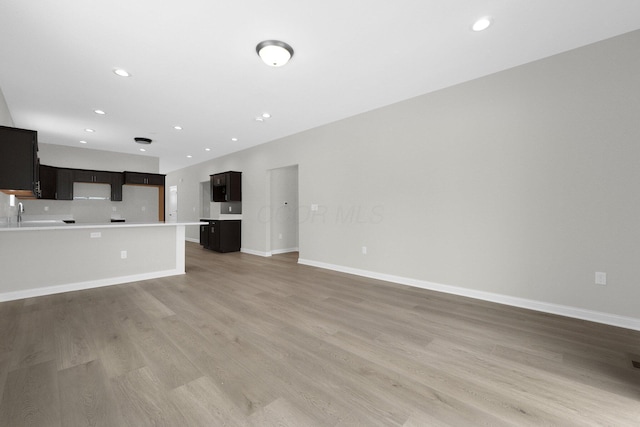 unfurnished living room with light wood-style flooring, baseboards, and recessed lighting