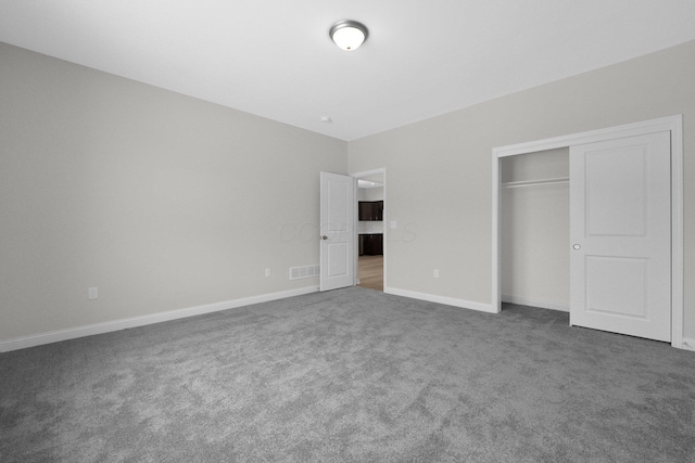 unfurnished bedroom featuring carpet floors, baseboards, visible vents, and a closet