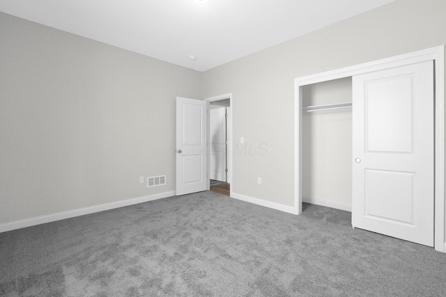 unfurnished bedroom with a closet, carpet flooring, visible vents, and baseboards