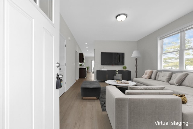 living area with light wood-style floors and recessed lighting