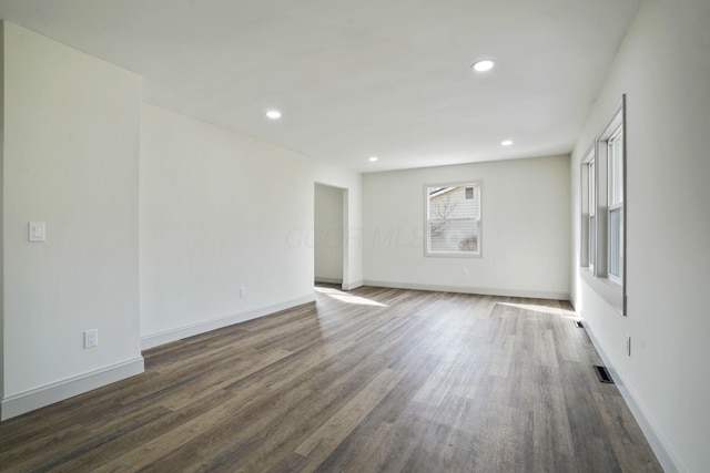 empty room featuring dark wood-style floors, recessed lighting, and baseboards