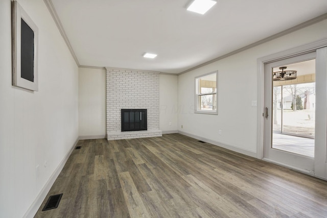 unfurnished living room with dark wood-style flooring, a fireplace, crown molding, and visible vents