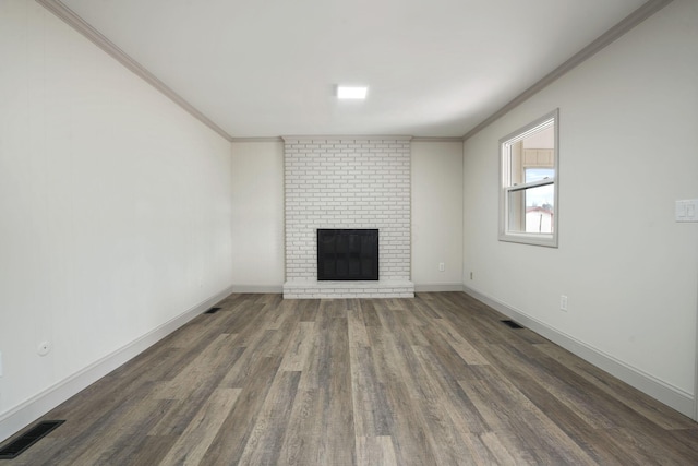 unfurnished living room featuring a fireplace, visible vents, dark wood-style flooring, and ornamental molding