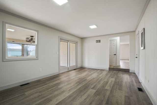 interior space with dark wood-style flooring, visible vents, crown molding, and baseboards