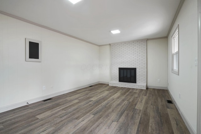 unfurnished living room featuring visible vents, a fireplace, ornamental molding, and dark wood-style flooring