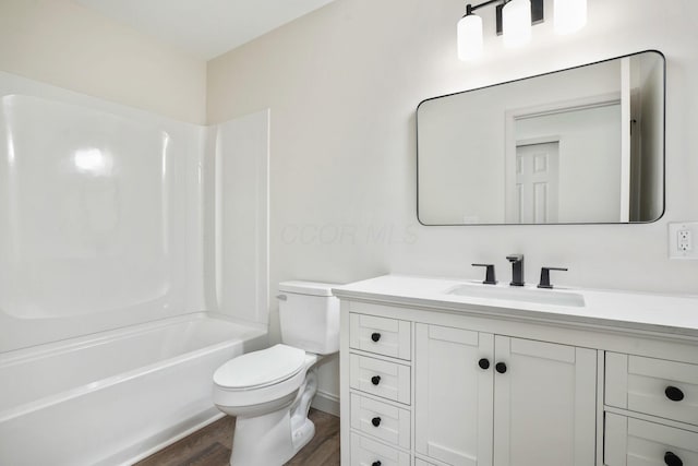 bathroom featuring wood finished floors, vanity, toilet, and shower / bathtub combination