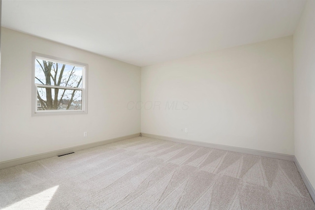 empty room with light carpet and baseboards