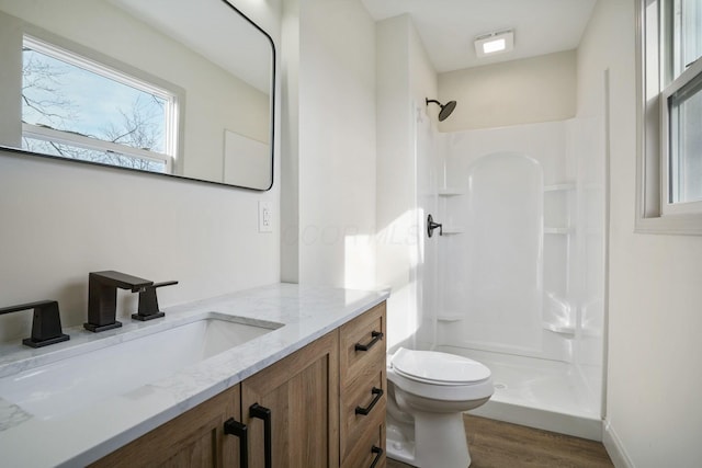 full bath featuring toilet, a stall shower, wood finished floors, and vanity