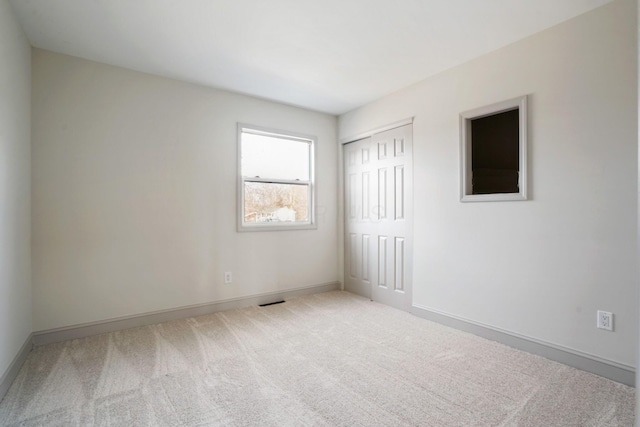 carpeted spare room featuring baseboards