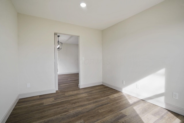 unfurnished room featuring baseboards, dark wood finished floors, and recessed lighting