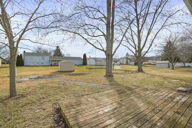 deck featuring a yard, a storage unit, and an outdoor structure