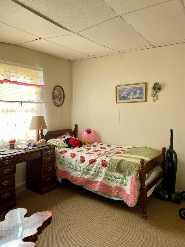 bedroom with a drop ceiling and carpet floors