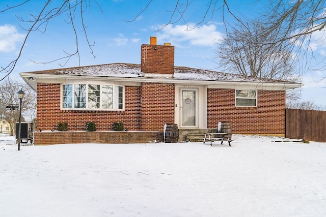 view of snow covered back of property