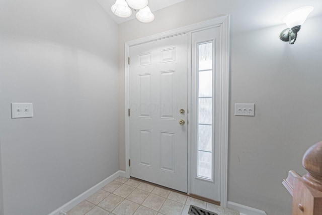 tiled foyer entrance featuring a chandelier