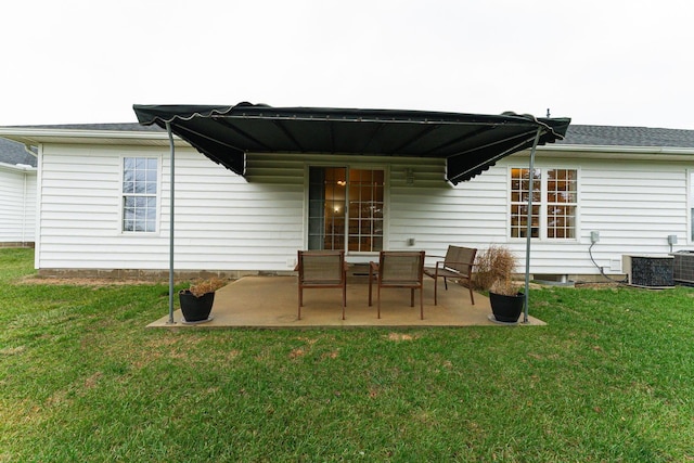 rear view of house featuring central AC unit, a patio, and a lawn