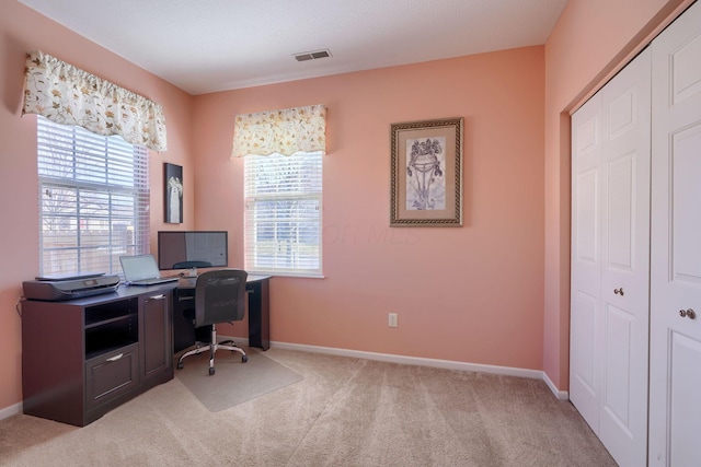 home office with plenty of natural light and light carpet