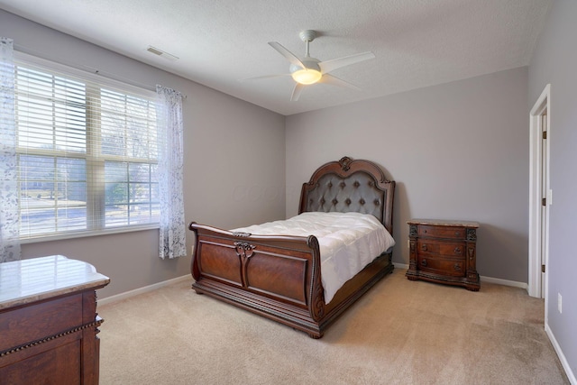 carpeted bedroom with ceiling fan and a textured ceiling