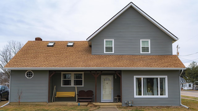 rear view of property with a lawn and a porch