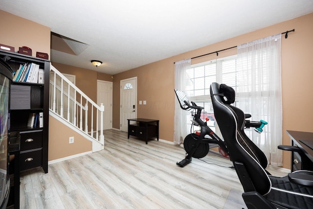 exercise room featuring light wood-type flooring