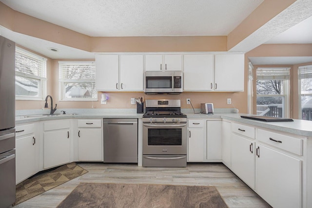 kitchen featuring white cabinetry, kitchen peninsula, and appliances with stainless steel finishes