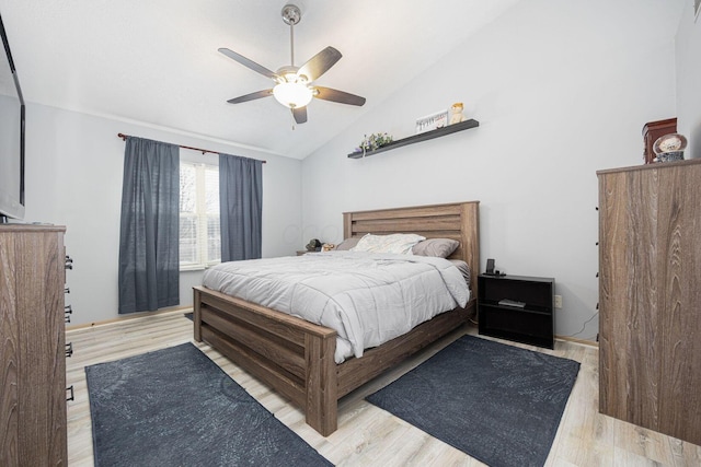 bedroom with light wood-type flooring, vaulted ceiling, and ceiling fan