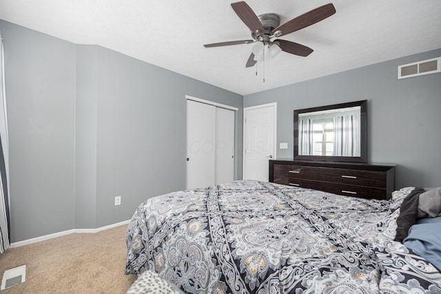 bedroom with carpet, a closet, ceiling fan, and a textured ceiling