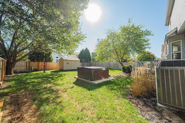 view of yard featuring a hot tub, a shed, and cooling unit