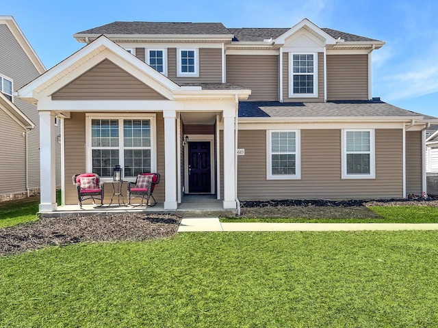 view of front of house featuring a front lawn, a porch, and a shingled roof