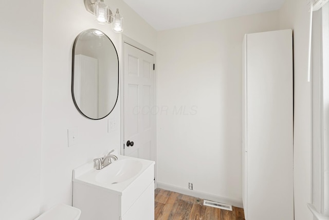 2029 Fairfax Ave, Columbus, OH 43207 - bathroom featuring vanity, wood finished floors, visible vents, and baseboards