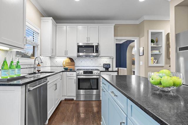 kitchen featuring stainless steel appliances, dark wood-style flooring, a sink, white cabinetry, and ornamental molding