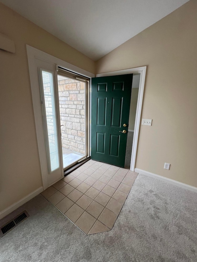 foyer entrance featuring lofted ceiling, carpet floors, visible vents, and baseboards