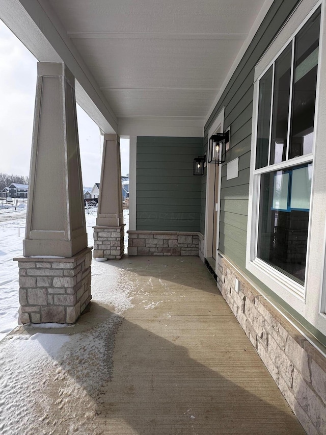 snow covered patio with a porch