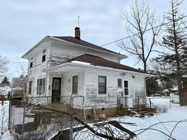 view of front of home with a fenced front yard, crawl space, and a chimney