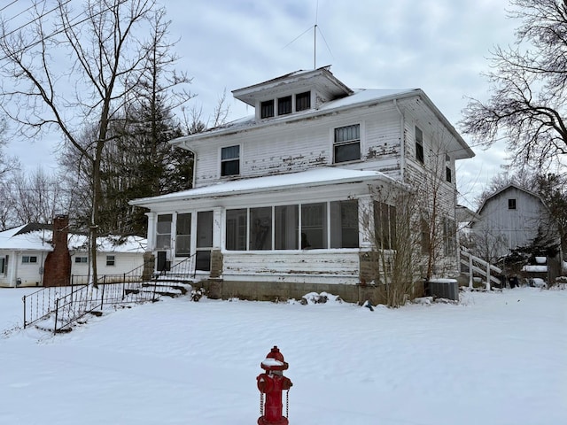 view of front facade featuring cooling unit, a sunroom, and fence