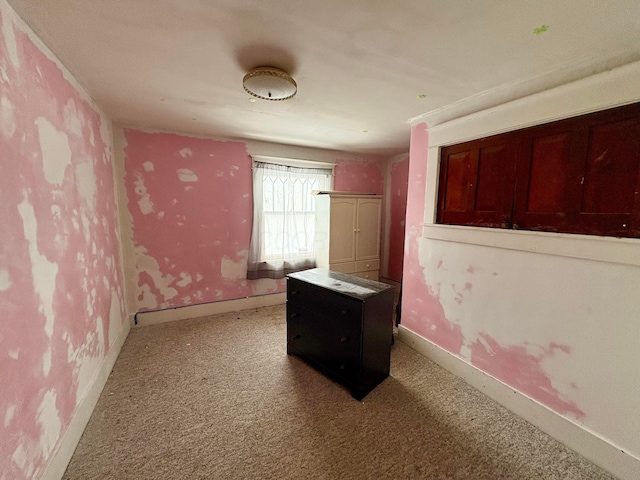 unfurnished bedroom featuring carpet floors and baseboards