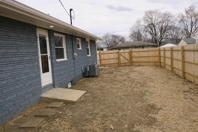 view of yard featuring a fenced backyard and central AC