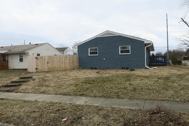 view of property exterior with fence and brick siding