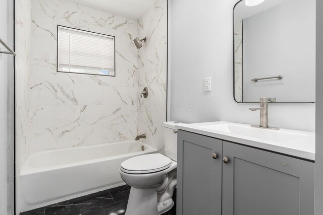 full bathroom featuring washtub / shower combination, marble finish floor, vanity, and toilet