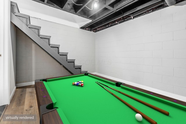 game room with concrete block wall, wood finished floors, and pool table