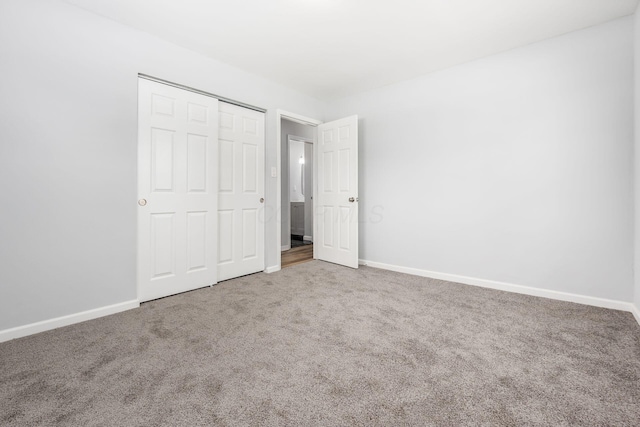 unfurnished bedroom featuring carpet floors, a closet, and baseboards