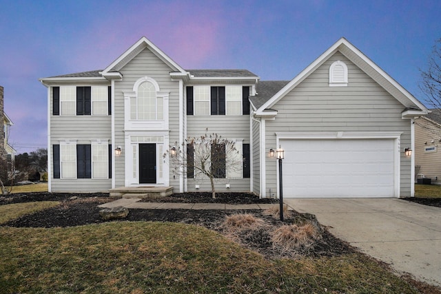 colonial-style house featuring a garage and driveway