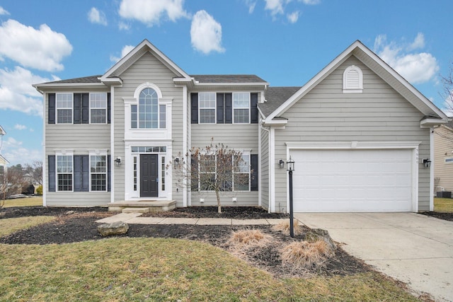 colonial home with a garage and concrete driveway