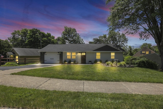 single story home with a garage and a lawn