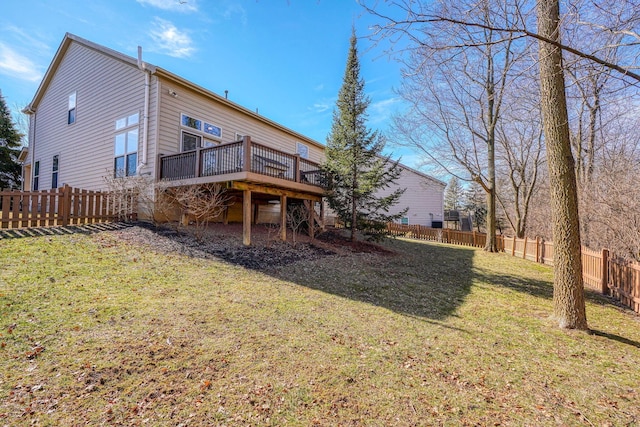 rear view of house featuring a wooden deck and a lawn